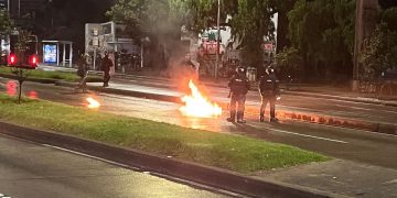 Este es el momento en que bomba molotov impacta a policía en disturbios de la Universidad Nacional
