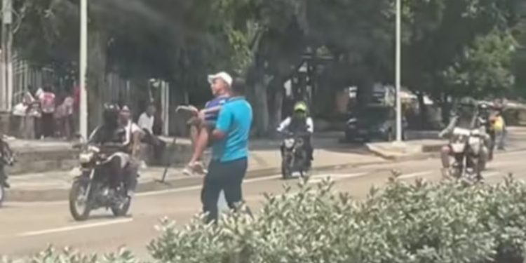 Conductor de bus en Barranquilla carga a un adulto mayor para ayudarlo a cruzar la concurrida vía Cordialidad